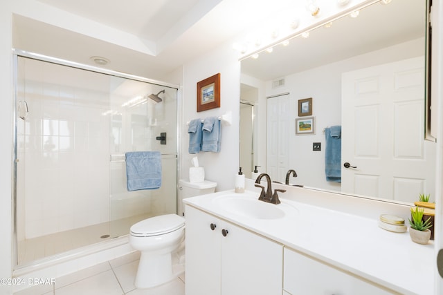 bathroom featuring toilet, vanity, tile patterned flooring, and a shower with door