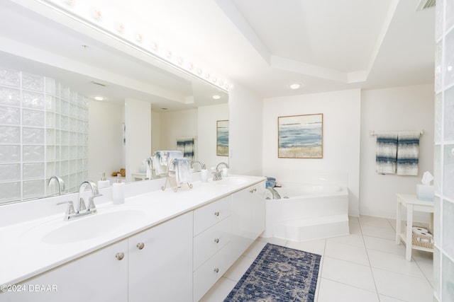 bathroom featuring tile patterned flooring, a washtub, vanity, and a raised ceiling