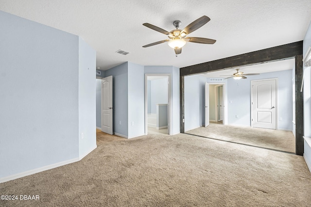 carpeted spare room featuring ceiling fan, beamed ceiling, and a textured ceiling