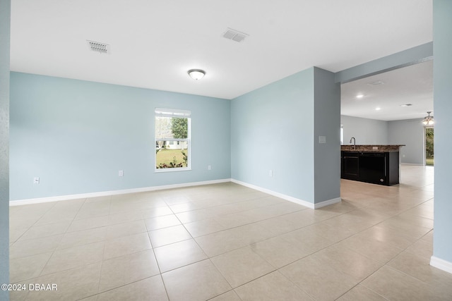 spare room with light tile patterned floors and sink