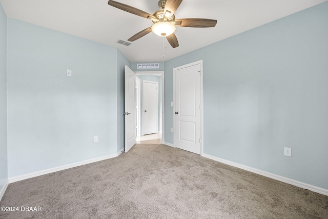 empty room featuring ceiling fan and light carpet