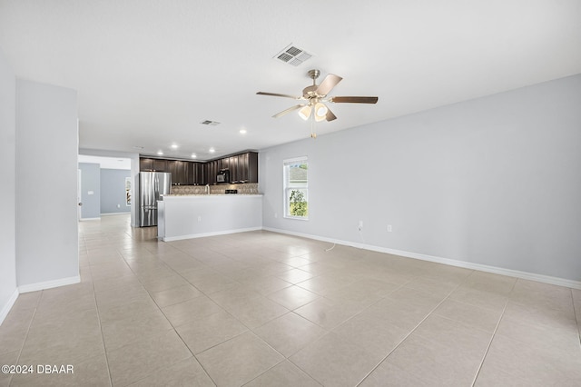unfurnished living room with sink, ceiling fan, and light tile patterned flooring