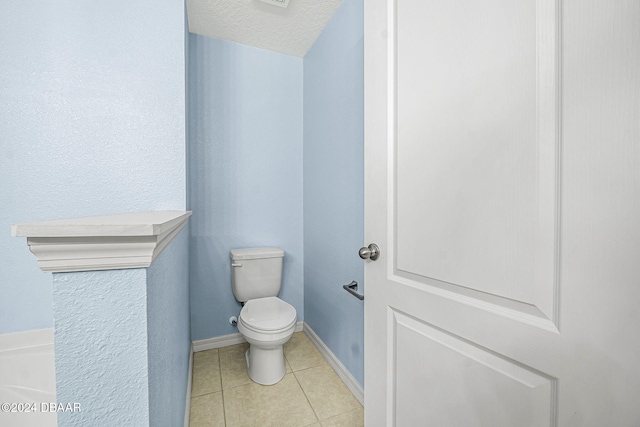 bathroom featuring tile patterned flooring, toilet, and a textured ceiling