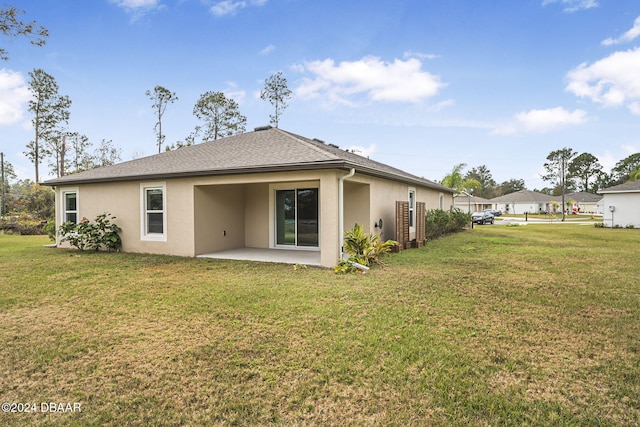 rear view of house with a lawn and a patio area