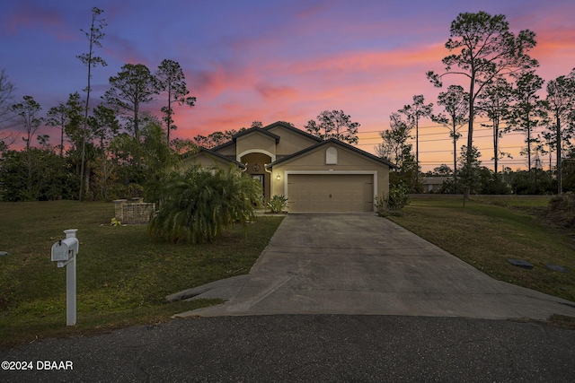 view of front of home with a yard and a garage