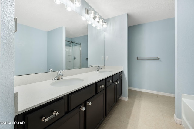 bathroom featuring tile patterned flooring, vanity, separate shower and tub, and a textured ceiling