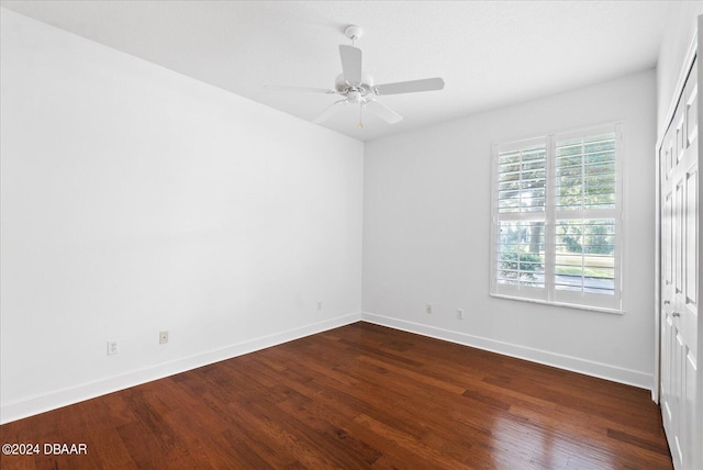 empty room with ceiling fan and dark hardwood / wood-style floors