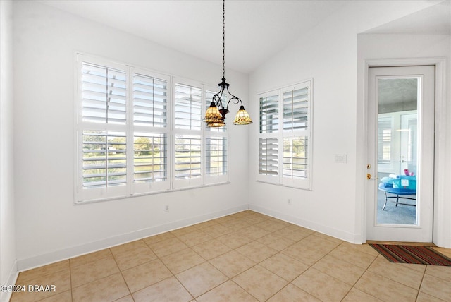 unfurnished dining area featuring an inviting chandelier, a wealth of natural light, lofted ceiling, and light tile patterned flooring