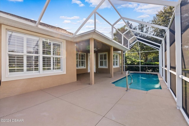 view of pool featuring ceiling fan, glass enclosure, and a patio area