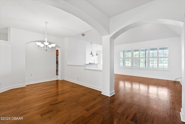 unfurnished living room featuring hardwood / wood-style floors and a notable chandelier