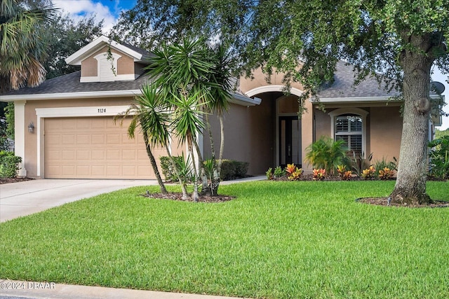 view of front of home with a garage and a front lawn