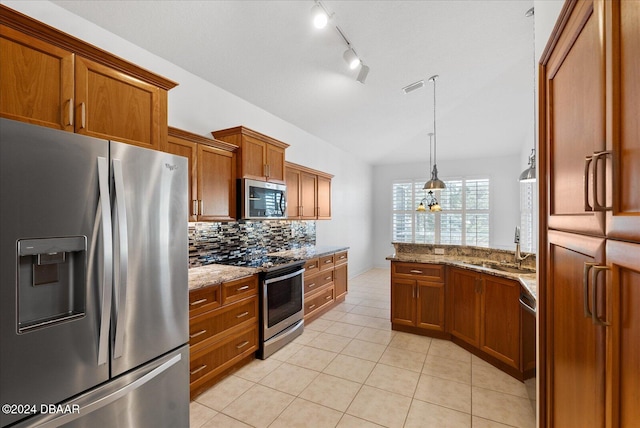 kitchen featuring light stone countertops, pendant lighting, appliances with stainless steel finishes, tasteful backsplash, and sink