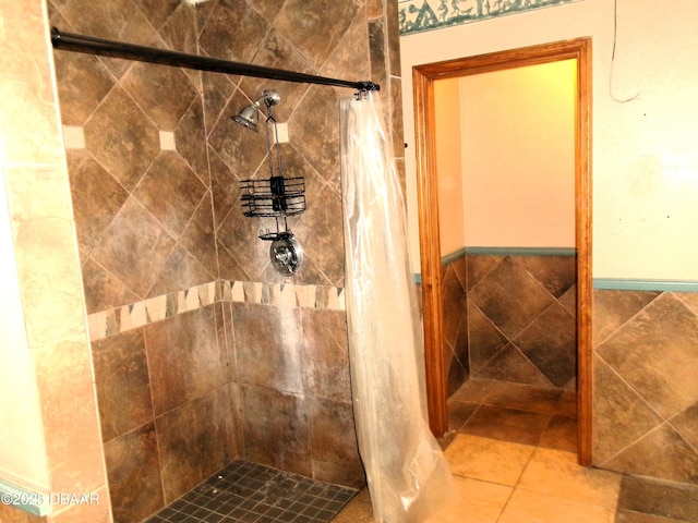 bathroom with tile patterned flooring, tile walls, and a tile shower