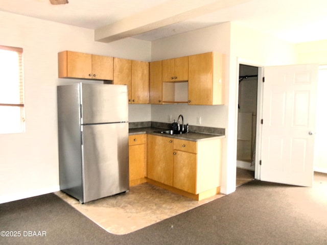 kitchen with sink, stainless steel fridge, and beam ceiling