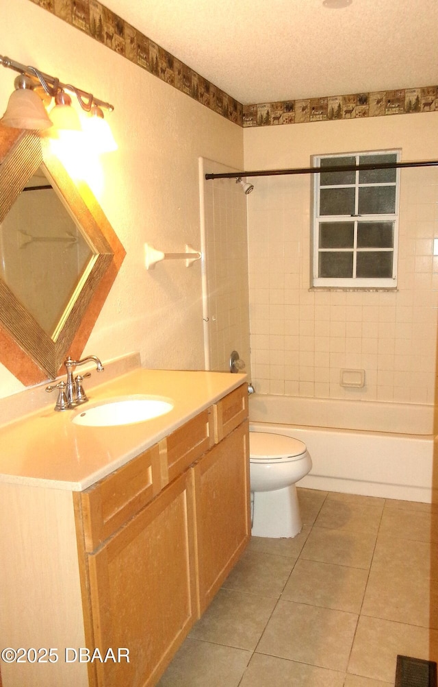 full bathroom with tile patterned floors, toilet, tiled shower / bath, a textured ceiling, and vanity