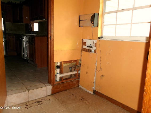 hallway featuring sink and light tile patterned floors