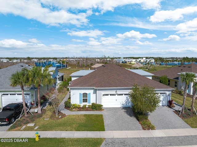 view of front facade with a garage, a residential view, and decorative driveway