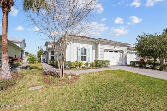 view of front of property featuring board and batten siding, a front yard, driveway, and an attached garage