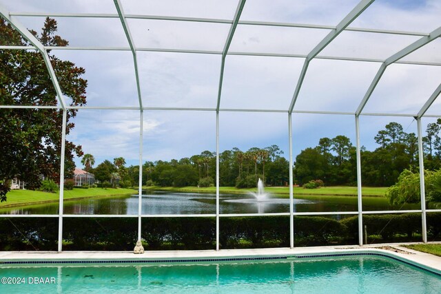 view of pool featuring a lanai and a water view