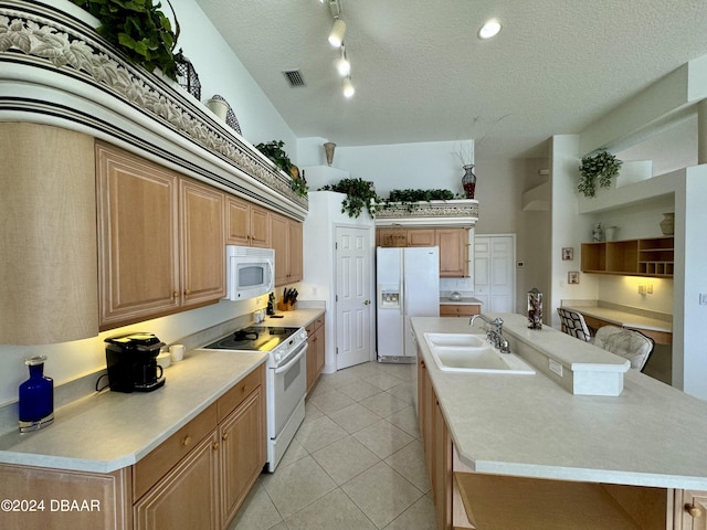 kitchen with a center island with sink, white appliances, vaulted ceiling, light tile patterned floors, and sink