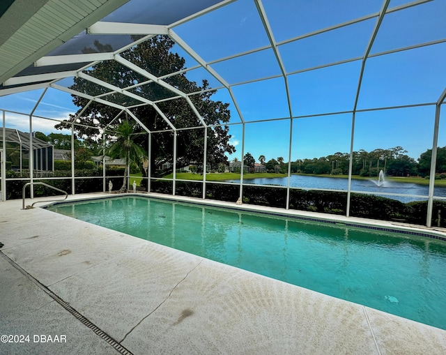 view of pool with a patio, a water view, and glass enclosure