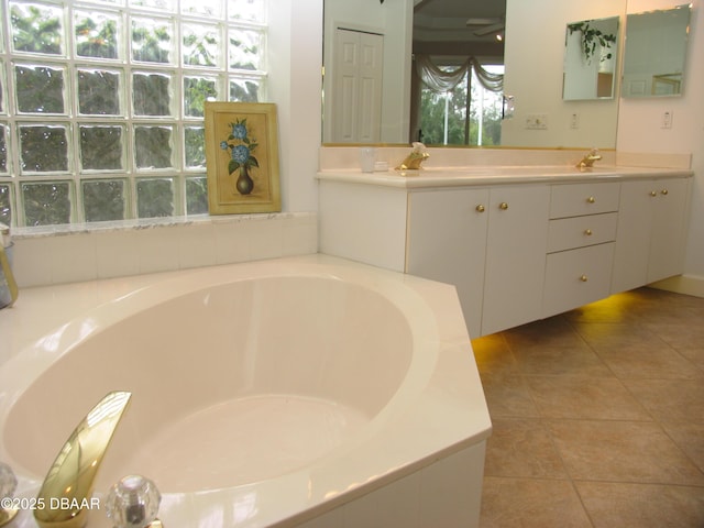 bathroom featuring tiled bath, tile patterned floors, and vanity