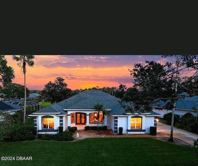 4 Lakewood Dr, Ormond Beach, FL 32174 - view of front of house featuring a front yard, stucco siding, roof with shingles, and driveway