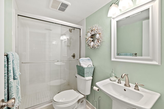 bathroom with walk in shower, sink, and toilet