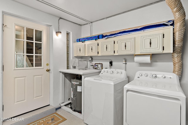 clothes washing area with washer and clothes dryer and cabinets