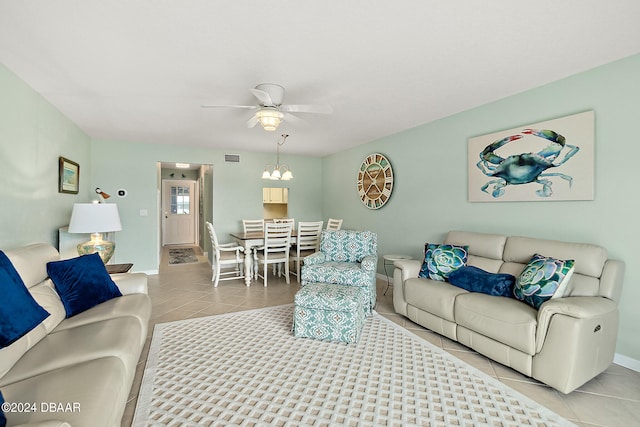 tiled living room featuring ceiling fan with notable chandelier