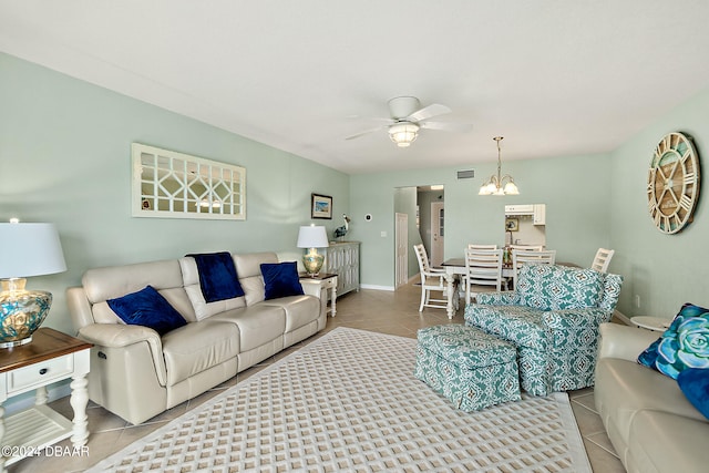 living room with light tile patterned flooring and ceiling fan with notable chandelier