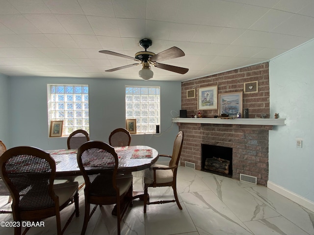 dining room featuring a brick fireplace and ceiling fan