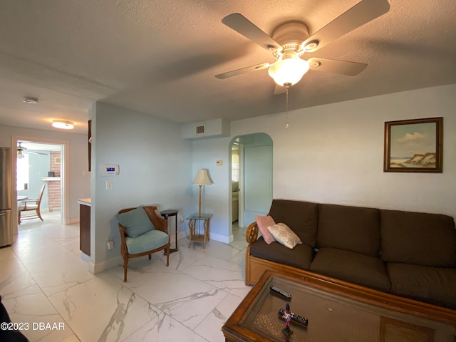 living room featuring a textured ceiling and ceiling fan