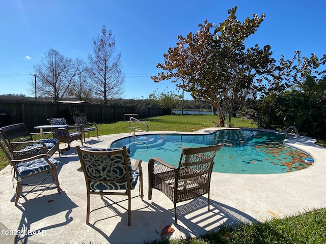 view of pool with a lawn and a patio area