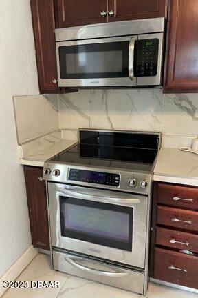 kitchen featuring decorative backsplash, stainless steel appliances, and light tile patterned flooring