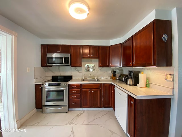 kitchen with stainless steel appliances, sink, and tasteful backsplash