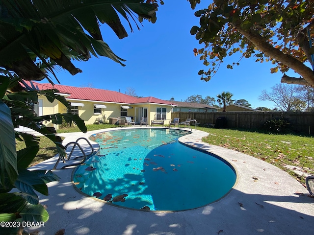 view of pool with a lawn and a patio