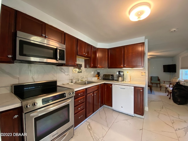 kitchen featuring stainless steel appliances, sink, and backsplash