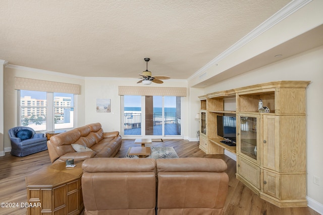 living room with hardwood / wood-style floors, ceiling fan, a textured ceiling, and ornamental molding