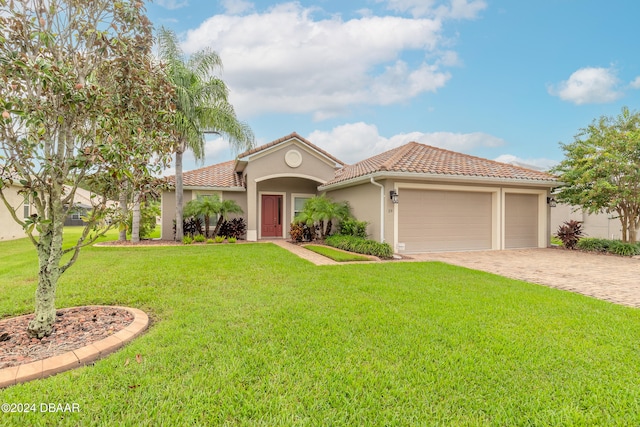 mediterranean / spanish-style home with a front yard and a garage