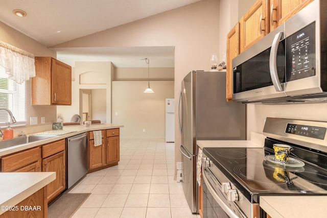 1692 Old Tomoka Rd Unit W, Ormond Beach, FL 32174 - kitchen featuring appliances with stainless steel finishes, vaulted ceiling, a sink, light countertops, and brown cabinets