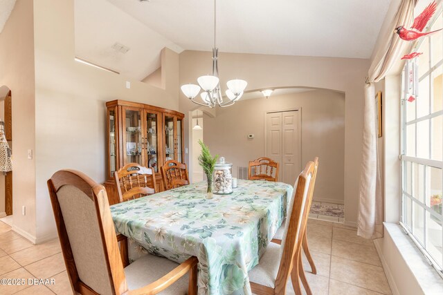 1692 Old Tomoka Rd Unit W, Ormond Beach, FL 32174 - dining area featuring arched walkways, light tile patterned flooring, lofted ceiling, a chandelier, and baseboards