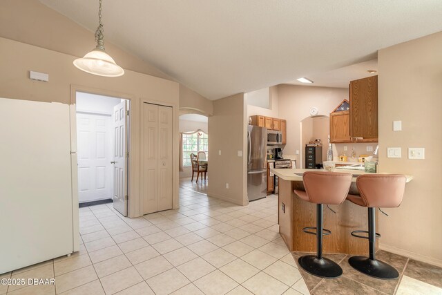 1692 Old Tomoka Rd Unit W, Ormond Beach, FL 32174 - kitchen with appliances with stainless steel finishes, lofted ceiling, arched walkways, light countertops, and brown cabinetry