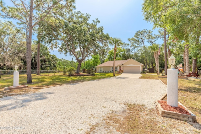 1692 Old Tomoka Rd Unit W, Ormond Beach, FL 32174 - view of front of house featuring driveway, an attached garage, and view of wooded area