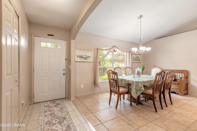 1692 Old Tomoka Rd Unit W, Ormond Beach, FL 32174 - dining space with healthy amount of natural light, a chandelier, light tile patterned floors, vaulted ceiling, and baseboards