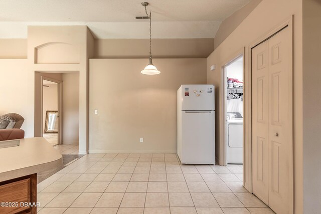1692 Old Tomoka Rd Unit W, Ormond Beach, FL 32174 - kitchen featuring freestanding refrigerator, washer / clothes dryer, light tile patterned flooring, decorative light fixtures, and lofted ceiling