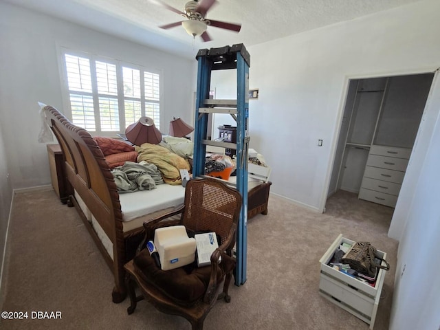 bedroom featuring a closet, a textured ceiling, light colored carpet, and ceiling fan