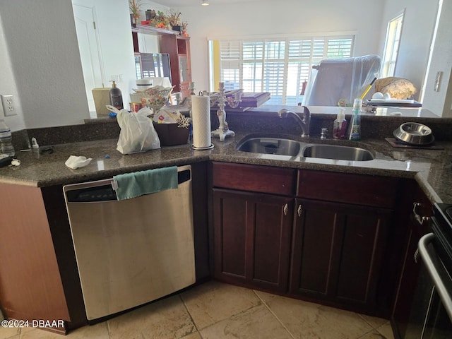 kitchen featuring dark stone counters, stove, sink, dishwasher, and kitchen peninsula