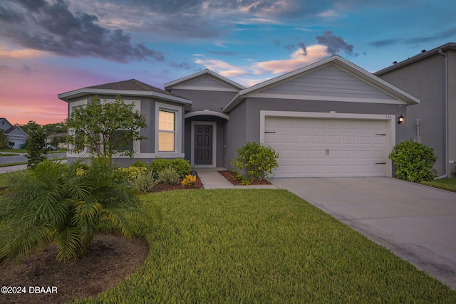 view of front facade with a garage and a lawn