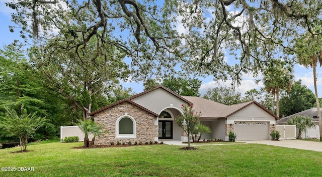 7 Traceway Ct, Ormond Beach, FL 32174 - view of front of home featuring stone siding, driveway, a garage, stucco siding, and french doors